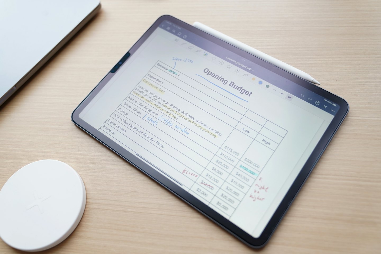 Tablet z cyfrowym arkuszem budżetowym i rysikiem na ekranie.